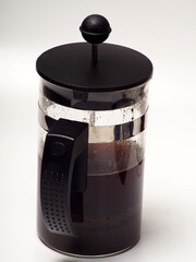 A cup of coffee and french press on a white isolated background