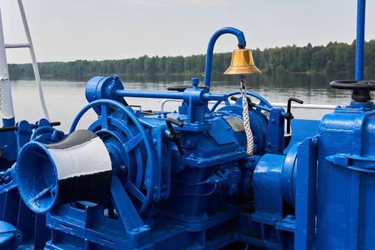 bell, capstan and other mechanisms, painted blue, on the foredeck of the river ship, close-up