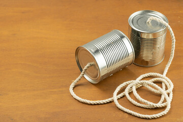 Cans joined by cord as a telephone