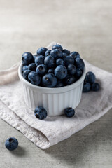 Lot of fresh delicious blueberries on a white pot over a wooden table