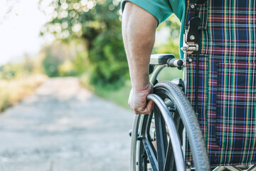 Naklejka premium disabled male in a wheelchair in a garden