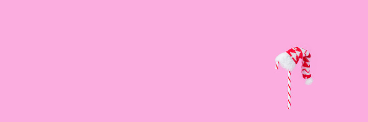 Christmas candies with Santa Claus hat on a bright pink background. Creative minimal Christmas art. Copy space.