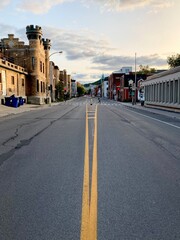 Montreal city empty road during Covid-19 times, few cars on the asphalt of central neighborhood Plateau Mont Royal with historical landmark nearby.