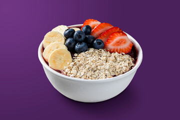 Brazilian frozen açai berry ice cream bowl with strawberries, bananas, blueberry and granola. isolated on purple background. Summer menu front view