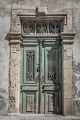 Obraz premium Old Medittaranean door in Cyprus with peeling paint but remnants of grandeur.
