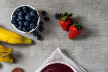 Brazilian frozen açai berry ice cream bowl. with fruits on wooden background. Summer menu top view. close up