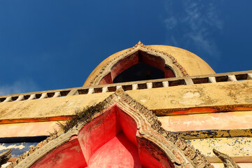 Thai Buddhist stupa in temple against blue sky background, Thailand. 