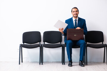 Young businessman waiting for an interview at hall