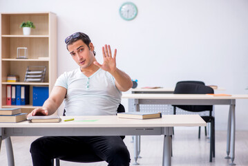 Young male student preparing for exam in the classroom