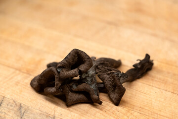 Black trumpet mushrooms on wooden background © PIERRE JEAN C