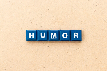 Tile letter in word humor on wood background