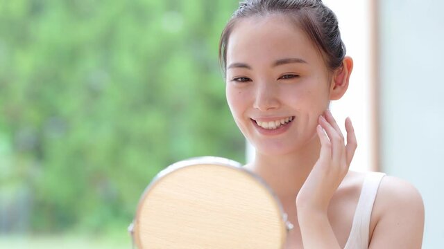 美容イメージ　スキンケア　お肌をチェックする日本人女性