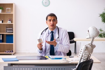 Young male doctor cardiologist and skeleton patient in the clini