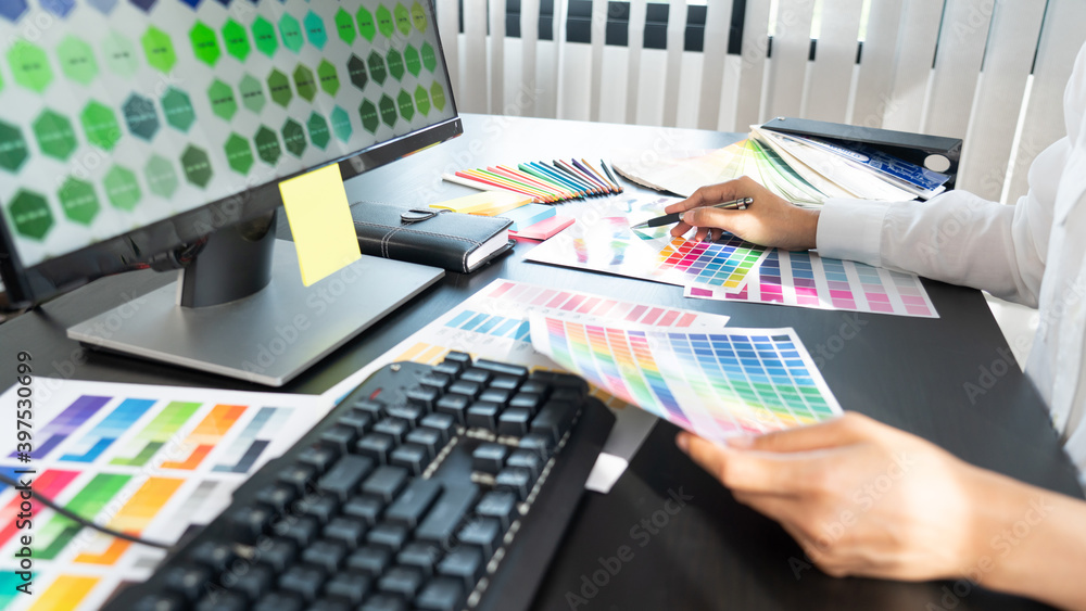 Poster creative graphic designer choosing color scale for editing artwork while working in office.