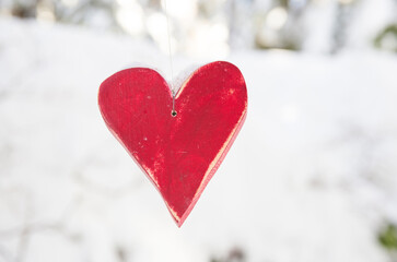 Wooden heart against snowy background