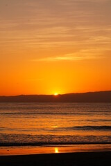 Fototapeta na wymiar ドラマティックな海岸の夕陽と波