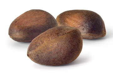 Three pine nuts on a white background. Full depth of field. With clipping path
