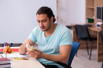 Young male student medic studying human anatomy at home