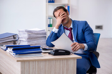 Young male employee reading contract paper in the office