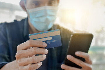 Close up hand holding mobile phone shopping online with credit, Man stay at home protect coronavirus covid19