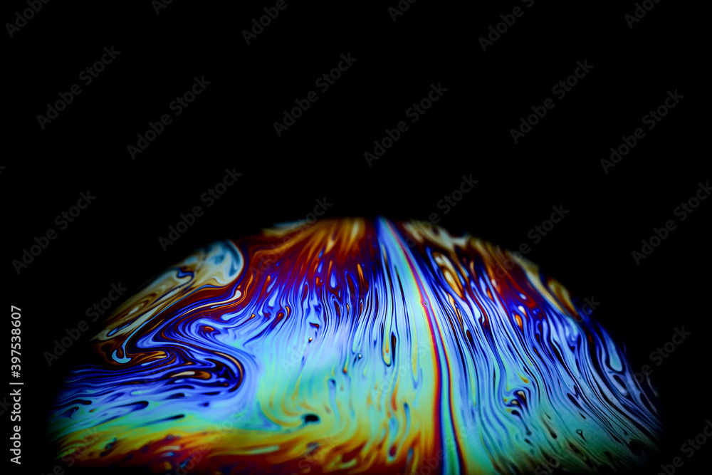 Wall mural macro picture of half soap bubble on black ground look like abstract psychedelic color planet in spa