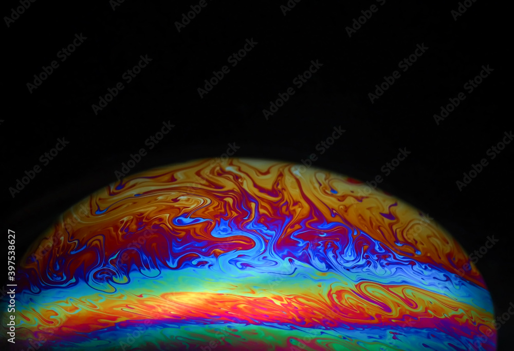 Wall mural macro picture of half soap bubble on black ground look like abstract psychedelic color planet in spa