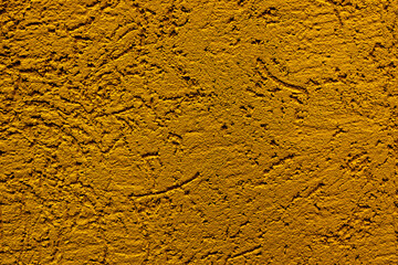 The wall is made of plaster with scratches. Rough surface. abstract background of yellow color. A template for the design of a website or ad.