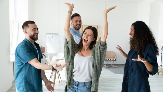 Banner panoramic view of overjoyed multiracial young employees have fun celebrate win or victory in office. Happy diverse multiethnic colleagues feel excited dance triumph together at workplace.