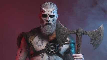 Violent and scary northern undead warrior with pale skin and horns posing in smokey dark red background holdgin two handed double axe and staring at camera with blue eyes. - Powered by Adobe