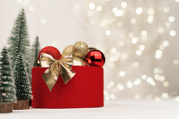 Christmas background , red gift box with a Golden bow on the background of Christmas bokeh. Copy Space