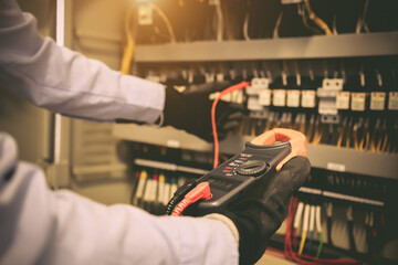 Close-up hand of electrical engineer using measuring equipment to checking electric current voltage...