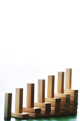 Stick wood block standing on stacked square wood blocks, abstract background in concept of winning, success, challenge, step to top position.