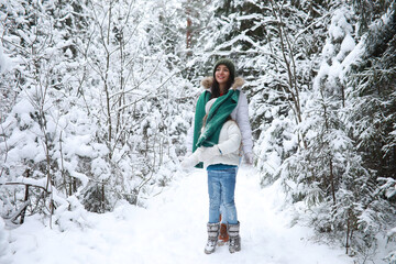 Young family for a walk. Mom and daughter are walking in a winter park.