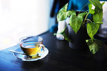 Hot steaming green tea in a cup on a rustic background