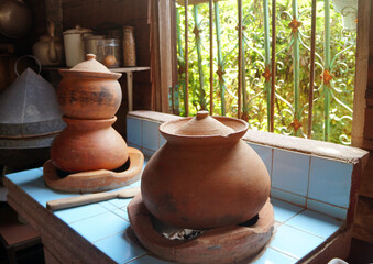 Fototapeta na wymiar Clay pots set on the stove as kitchen appliances. Retro Antique or vintage style.