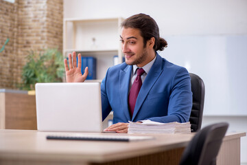 Young male employee sitting in the office in front of whiteboard