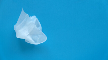 Top view of wet tissue isolated on a blue background with copy space.
