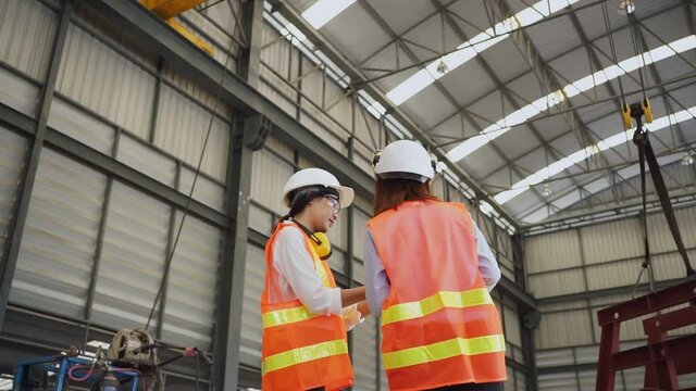 Female engineers are inspecting the workpiece in a steel factory.