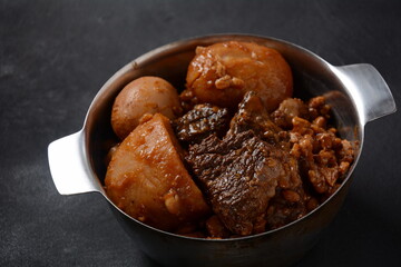 Jewish cuisine - Cholent (Hamin).Traditional main dish for Jewish Shabbat lunch, slow cooked beef Stew with potato, beans, barleys, wheat and brown eggs in a metal casserole