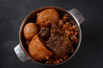 Jewish cuisine - Cholent (Hamin).Traditional main dish for Jewish Shabbat lunch, slow cooked beef Stew with potato, beans, barleys, wheat and brown eggs in a metal casserole