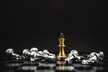 Close up king chess standing on chess board with falling chess concepts of business team and leadership strategy and organization management.