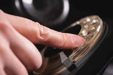 Woman is dialing the number on the old rotary phone close up.
