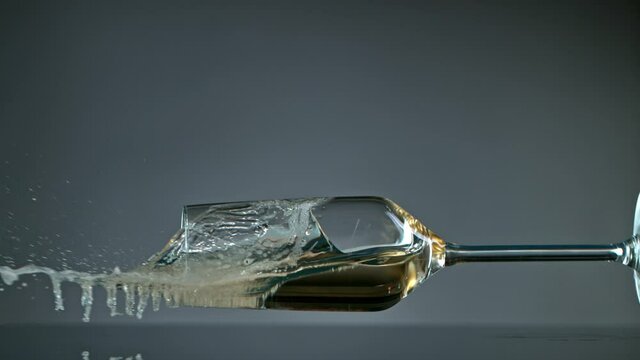 Falling Glass with Champagne on Grey Background at 1000 fps.