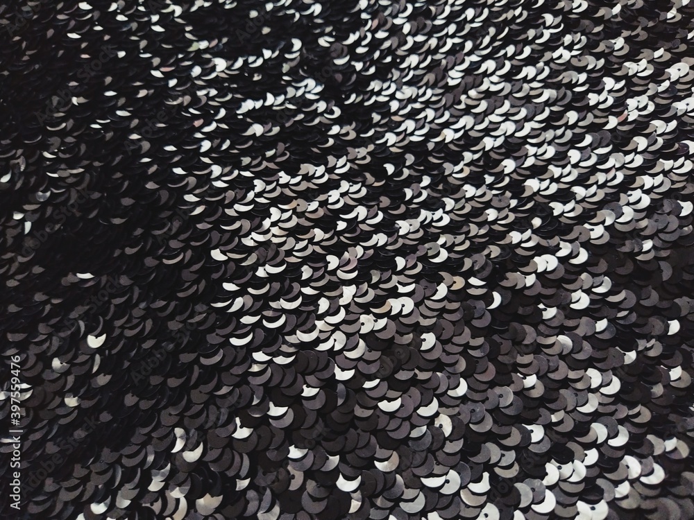 Poster sequin fabric. black sequins with white and gray sheen. reflection of light on individual elements i