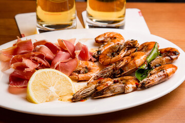 Beer snack of cold meats and fresh boiled shrimp with spices and lemon