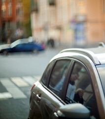 Car hood with window and people reflection on blurred street background.