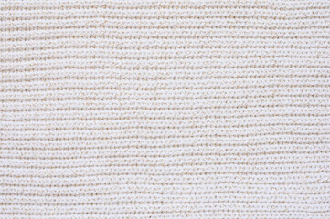 White knitted woolen fabric texture. Knitted white background with horizontal direction. Focusing in the center of the frame