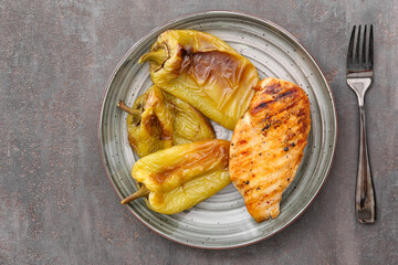 Plate with grilled bell peppers on dark table