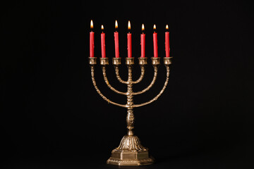 Fototapeta premium Golden menorah with burning candles on black background