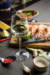 glass of white table wine with a variety of snacks. Dry white wine in the glass.
